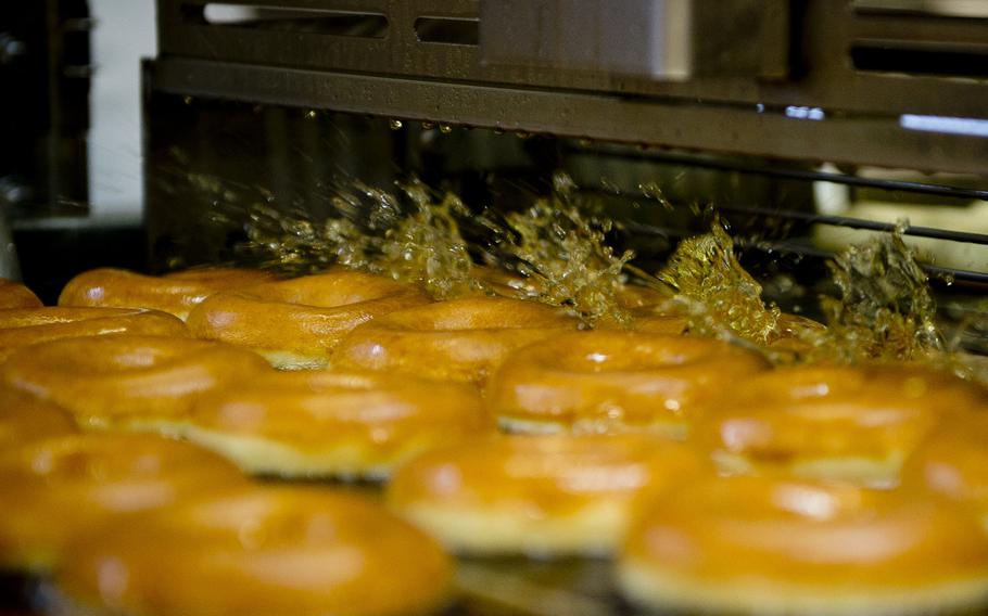 Krispy Kreme doughnuts are dunked in hot oil at the Exchange Bakery Europe in Gruenstadt, Germany, on Monday, Nov. 9, 2015. AAFES uses actual Krispy Kreme ingredients, equipment and recipes to produce the doughnuts bound for exchange stores across Europe.