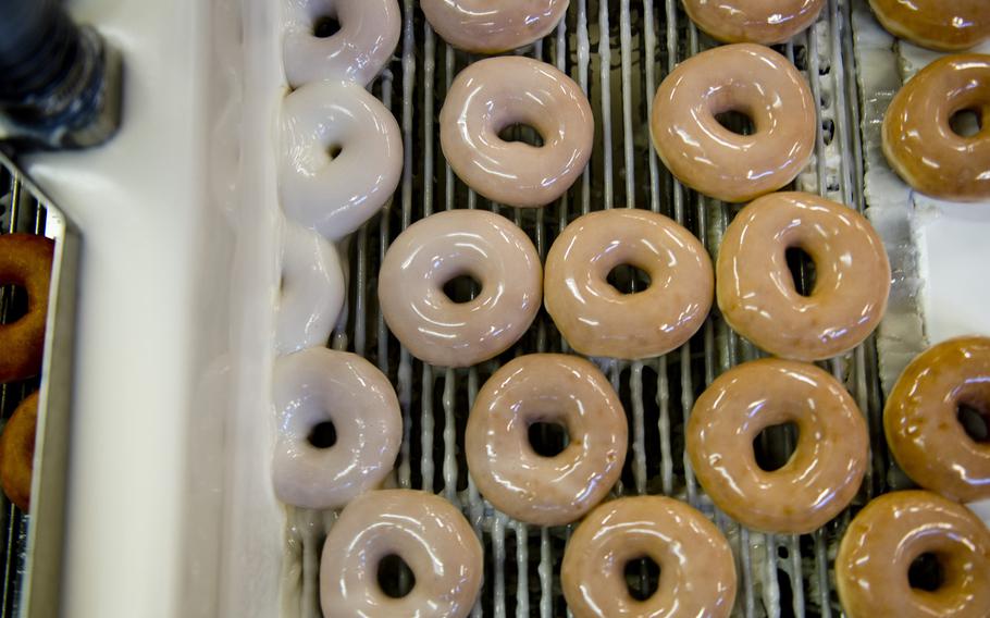 Krispy Kreme doughnuts are coated with icing at the Exchange Bakery Europe in Gruenstadt, Germany, on Monday, Nov. 9, 2015. This is the first AAFES production run of Krispy Kreme doughnuts in Europe.