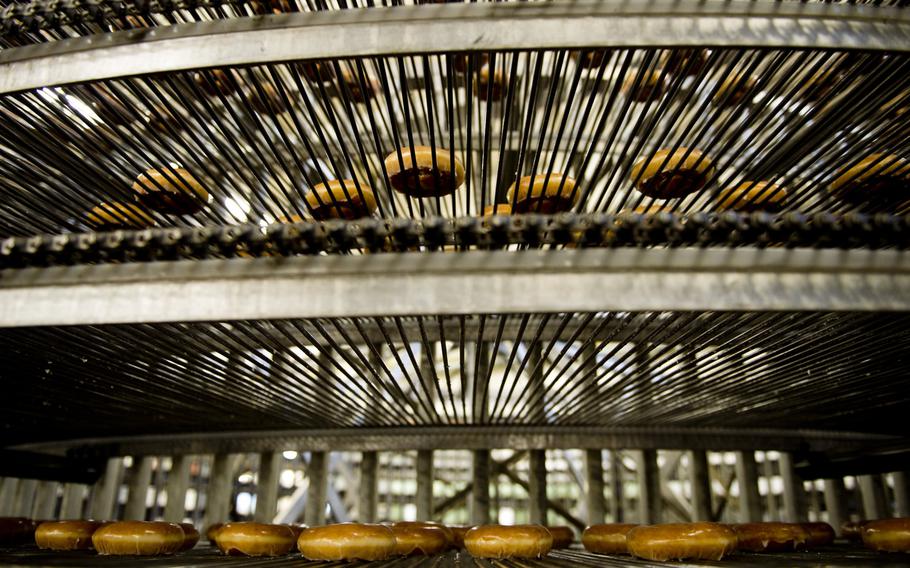 Krispy Kreme doughnuts travel on the conveyor belt to the boxing station at the Exchange Bakery Europe in Gruenstadt, Germany, on Monday, Nov. 9, 2015. AAFES uses actual Krispy Kreme ingredients, equipment and recipes to produce the doughnuts bound for exchange stores across Europe.