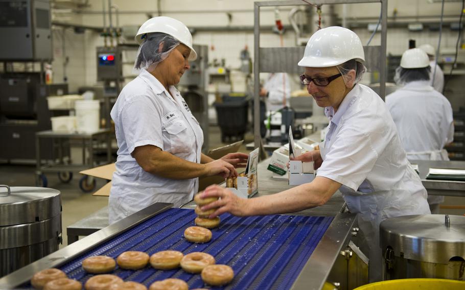 Workers box Krispy Kreme doughnuts at the Exchange Bakery Europe in Gruenstadt, Germany, on Monday, Nov. 9, 2015. Thousands of doughnuts will be baked each week and distributed to exchange stores across Europe.