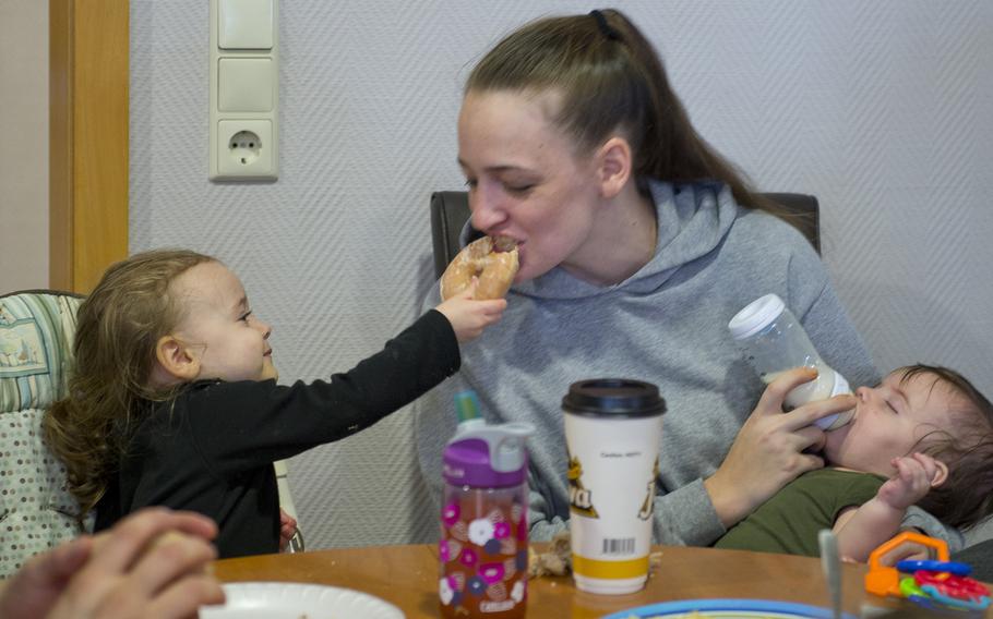 Valerie Mathieu has a bite of her daughter's Krispy Kreme doughnut at the Fisher House at Landstuhl, Germany, on Monday, Nov. 9, 2015. The Exchange Bakery Europe is producing and distributing Krispy Kreme doughnuts in Europe for the first time.