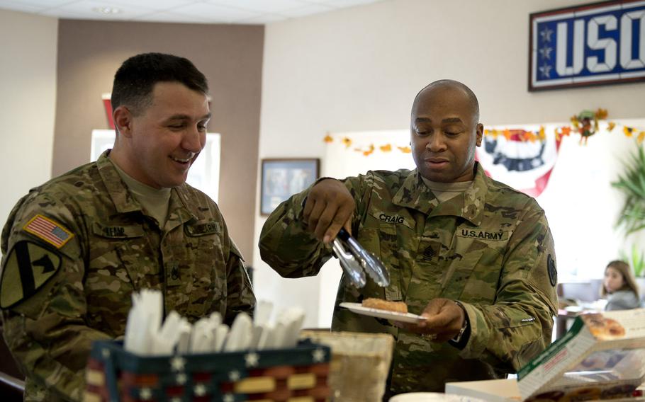 Army Sgt. Maj. Keith Craig, senior enlisted adviser to the Exchange in Europe and Southwest Asia, right, serves a Krispy Kreme doughnut to deployed Army Staff Sgt. Terry Kemp at the USO Warrior Center at Landstuhl, Germany, on Monday, Nov. 9, 2015. Craig delivered more than 50 boxes of doughnuts to the Landstuhl Regional Medical Center, Landstuhl Fisher Houses and the USO Warrior Center.