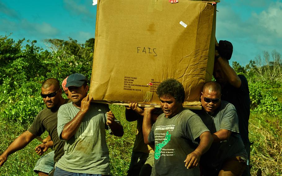 Men from Fais in the Federated States of Micronesia recover an airdropped box somewhere in the middle of their island Dec. 8, 2015. The villagers have no vehicles, so they must hand carry this 500-pound box for nearly 20 minutes through the jungle and into the village for the chief to sort and distribute.