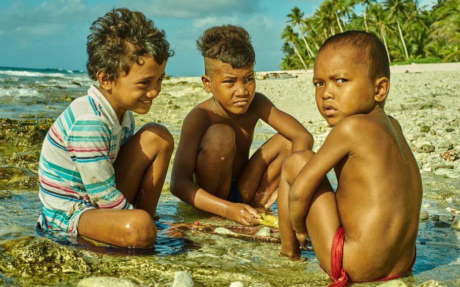 Three boys who live on the island of Fais play in the tide Dec. 8, 2015. Despite living 175 miles from the nearest state in Micronesia, every person on the island of school age and older is literate in at least two languages and speaks their native language and English fluently.