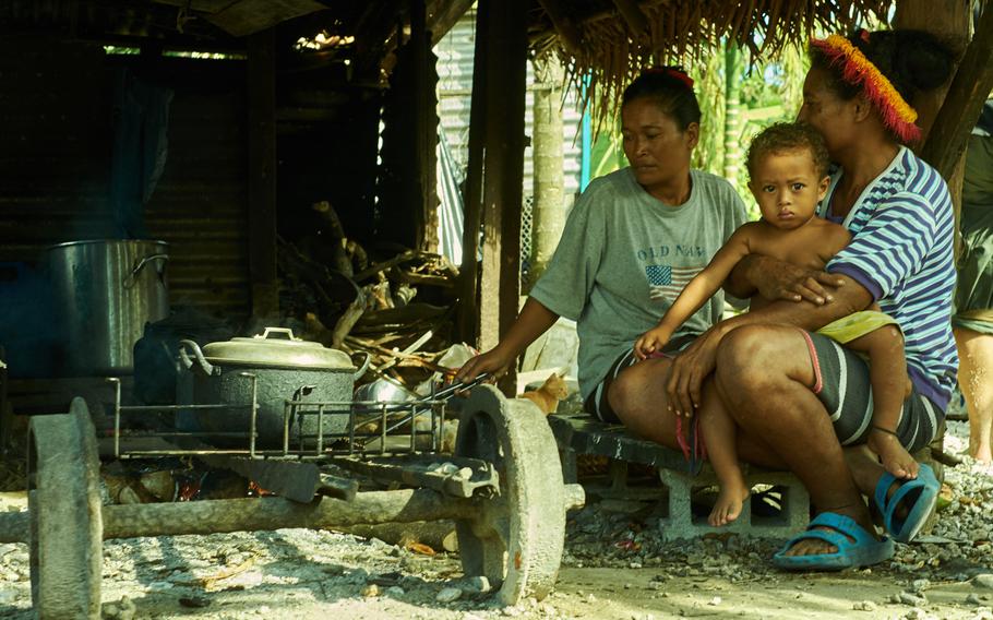 A family living on the island of Fais in the Federated States of Micronesia prepares dinner in their home Dec. 8, 2015. The stove they are using is a repurposed mine cart from a World War I era phosphate mine left behind by the Japanese. Many kitchens on the island have similar stoves.