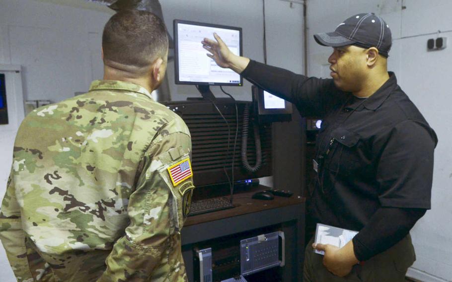 John Chatman, right, manager of the AAFES Taunus Theater in Wiesbaden, Germany, shows some of the theater's new equipment to Command Sgt. Maj. Larry Addington, Wiesbaden garrison senior noncommissioned officer, before the theater's grand re-opening, Dec. 17, 2015. The theater now uses an all-digital centralized projection system rather than film projectors.