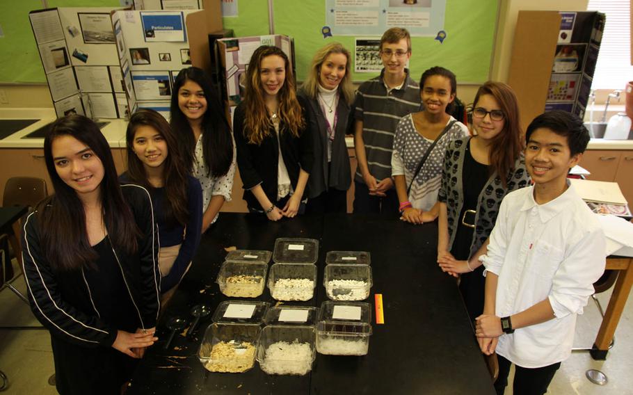 Eight classmates from Lester Middle School at Camp Lester on Okinawa, Japan, used mealworms and darkling beetles -- the worms' adult form -- to successfully biodegrade petroleum-based polyethylene plastic shopping bags and polystyrene Styrofoam. The fecal matter byproduct of the experiment, performed in Maryanne Tirinnanzi's eighth-grade science class, was nontoxic, they said. From left to right: Melody Seiber, Iris Frilles, Celeste Hernandez, Cecilia Braud, Maryanne Tirinnanzi, Peter Gillen, Chyna Daniel, Lexus Haight and Noah Buenaobra.