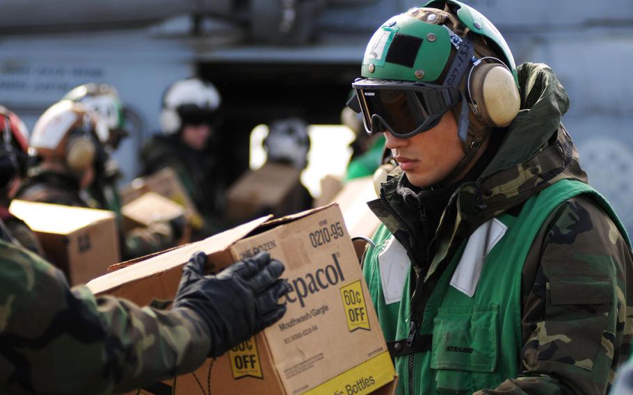 A U.S. sailor loads humanitarian assistance supplies onto an SH-60F Sea Hawk aboard the aircraft carrier USS Ronald Reagan on March 21, 2011. The Reagan, along with 15 other ships that took part in the relief effort, still have some radiation contamination more than five years later, the Navy says. Sailors aboard the ships, however, are not in any danger.