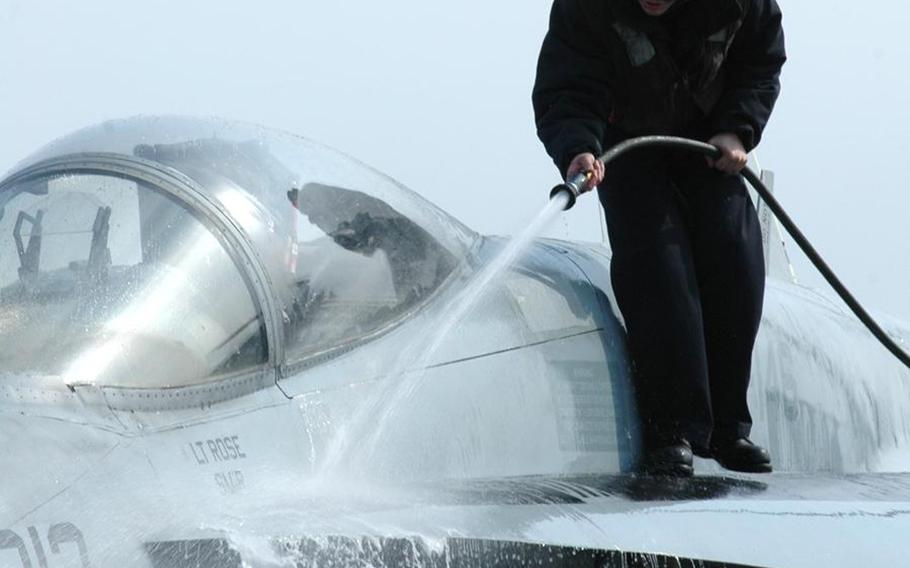 A sailor aboard the aircraft carrier USS Ronald Reagan washes an F/A-18C Hornet during Operation Tomodachi in March 2011. Sailors scrubbed the external surfaces on the flight deck and island superstructure to remove potential radiation contamination.