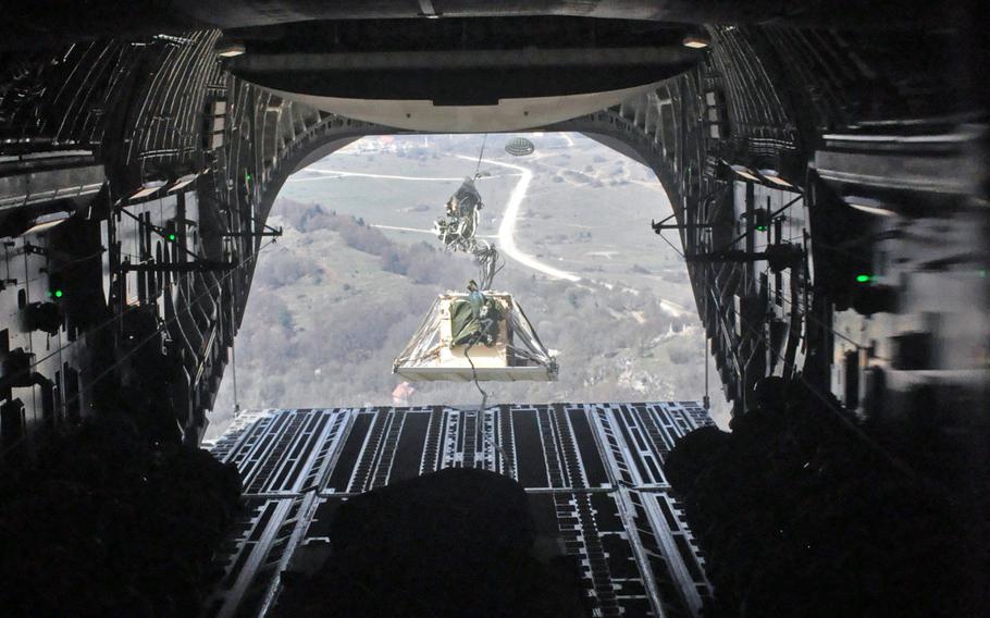 A parachute begins to deploy as a pallet loaded with equipment leaves the cargo hold of a C-17 flying over Hohenfels, Germany, on Monday, April 11, 2016, as part of  exercise Saber Junction.