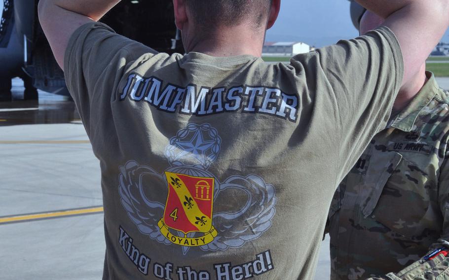 A jumpmaster from the 173rd Airborne Brigade sporting a T-shirt invoking one of the unit's famous nicknames "The Herd," stretches out while waiting for troops to load onto a C-130 at Aviano Air Base, Italy, as part of exercise Saber Junction.