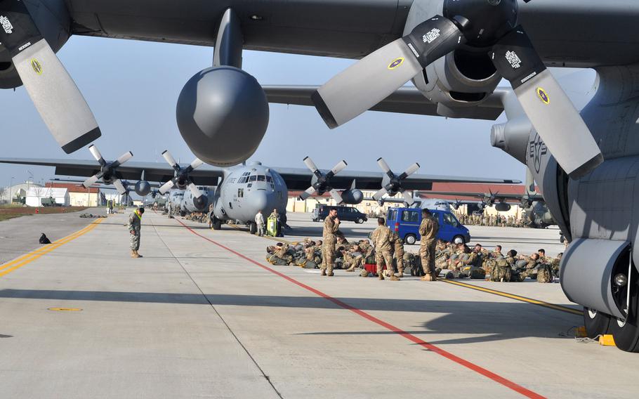 Groups of soldiers from the 173rd Airborne Brigade and allies  participating in exercise Saber Junction are camped out behind C-130 transport planes parked on the south ramp at Aviano Air Base, Italy, on Tuesday, April 12, 2016.