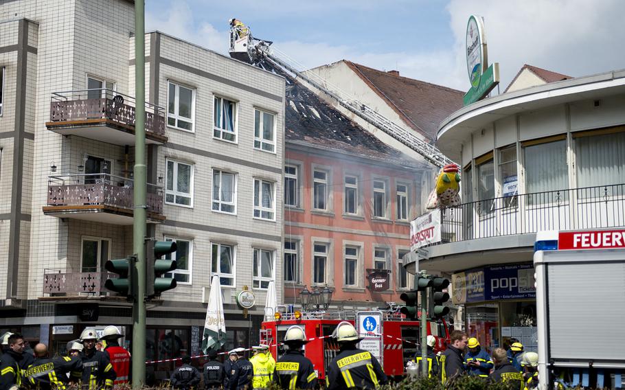 First responders stand by as firefighters work to completely extinguish a fire at the Hannenfass restaurant in Kaiserslautern, Germany, on Tuesday, May 3, 2016.