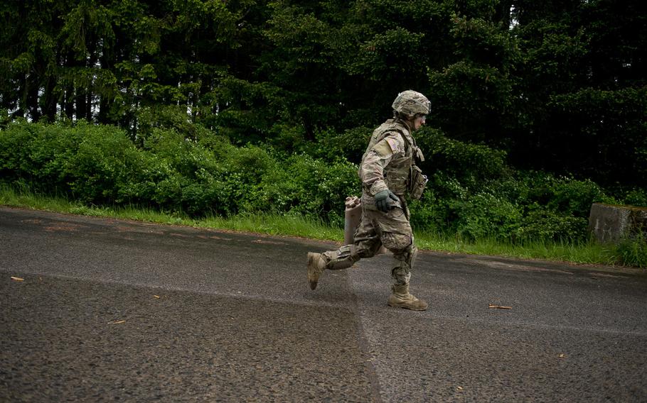 Sgt. Timothy Harris from the 18th Military Police Brigade runs down a hill with a 5-gallon jug of water during the 21st Theater Sustainment Command Best Warrior Competition in Baumholder, Germany, on Monday, May 23, 2016.