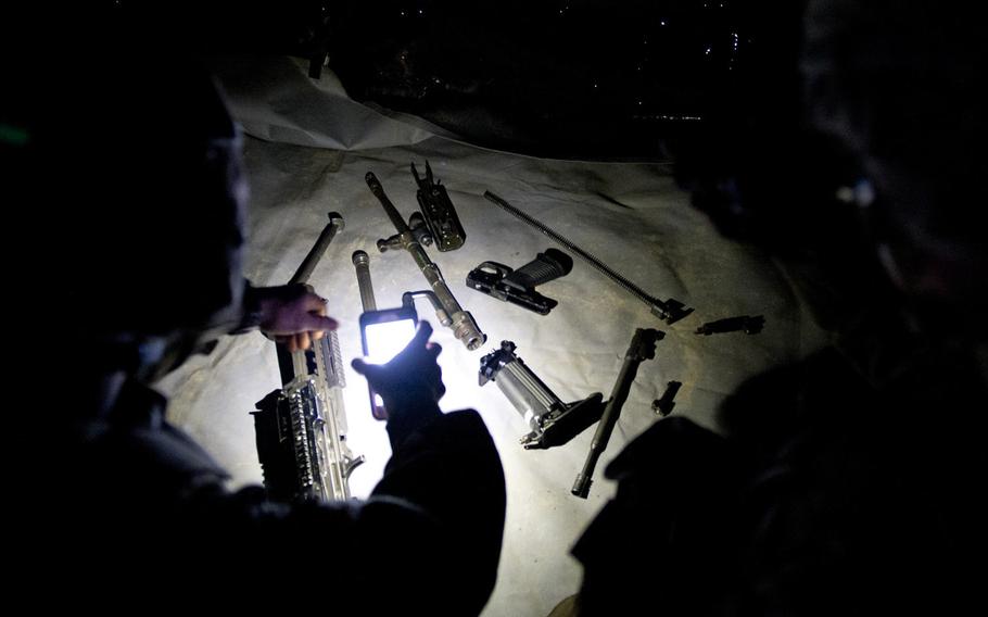 Inspectors count the number of M249 Squad Automatic Weapon parts during the 21st Theater Sustainment Command Best Warrior Competition in Baumholder, Germany, on Monday, May 23, 2016. Soldiers disassembled and reassembled light machine guns wearing night-vision goggles, and were scored on how quickly and accurately they could complete the task.