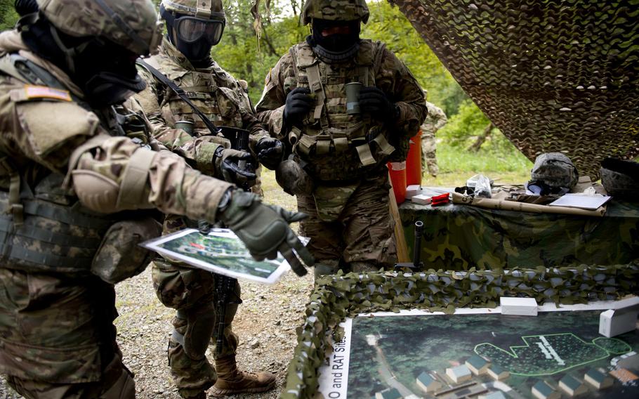 Competitors discuss their plan during a situational training exercise as part of the 21st Theater Sustainment Command Best Warrior Competition in Baumholder, Germany, on Monday, May 23, 2016. The team was tasked with locating simulated improvised explosive device components, treating casualties and capturing a high-value target.