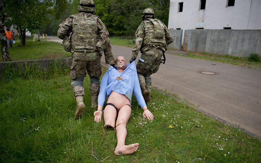 First Lt. Collin Welch, right, and Spc. Kevin Luquis move a simulated casualty during a situational training exercise as part of the 21st Theater Sustainment Command Best Warrior Competition in Baumholder, Germany, on Monday, May 23, 2016.