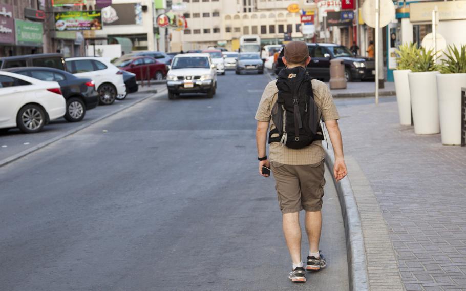 A man walks down ''American Alley'' in Juffair, Bahrain, wearing shorts and a short-sleeved shirt on Wednesday, June 1, 2016.  U.S. Naval Forces Central Command's change in clothing policy allows personnel and their families to wear shorts and short-sleeved shirts all year round with no additional clothing restrictions during Ramadan.