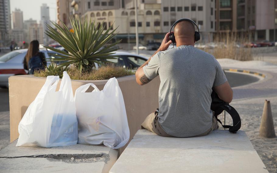 A U.S. Department of Defense employee sits near Naval Support Activity Bahrain waiting for a ride on Wednesday, June 1, 2016.   U.S. Naval Forces Central Command's change in clothing policy allows U.S.personnel and their families to wear shorts and short-sleeved shirts all year round with no additional clothing restrictions during Ramadan.