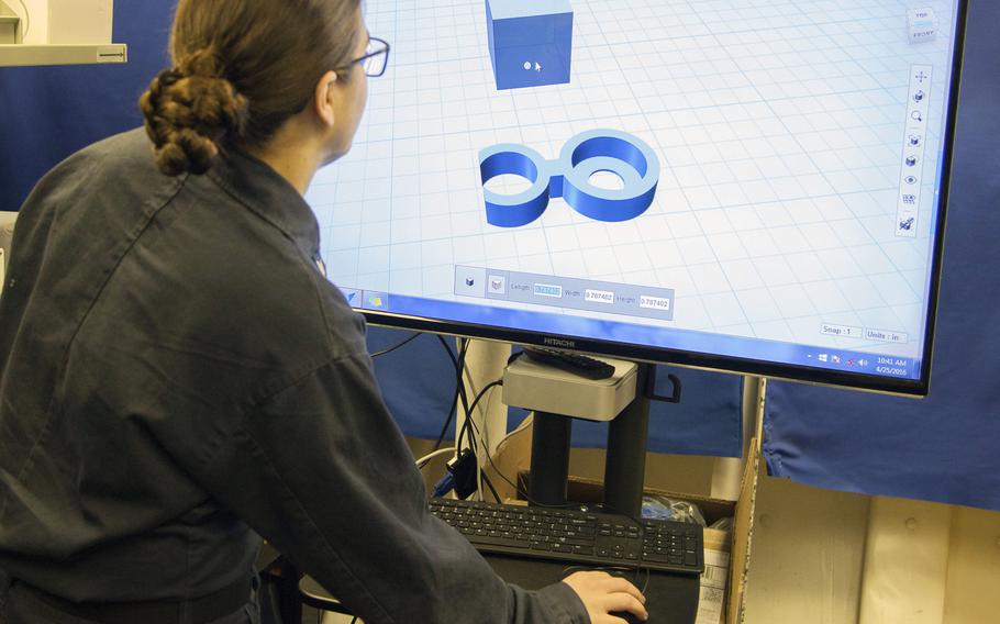 Petty Officer 2nd Class Ashley Figert, a 3D print technician aboard the aircraft carrier USS Harry S. Truman, shows how to create products with the computer-aided design program.  The ''Tru Clip'' design being shown here is being shared with the International Space Station, where it will be used by astronauts.