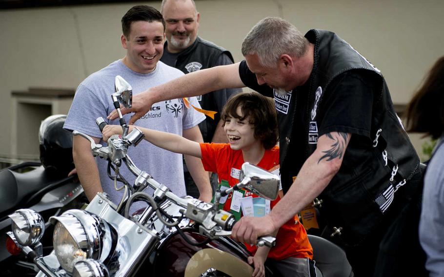 Stuttgart Elementary's Kieran Luckritz, center, laughs while revving a motorcycle with his buddy, Senior Airman Emmanuel Villarreal, left, and motorcycle owner Hans Beysiegel during the Spring Special Olympics at Ramstein Air Base, Germany, on Friday, June 3, 2016. 

Michael B. Keller/Stars and Stripes