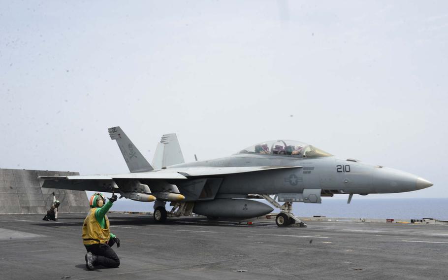 Deck crewmembers signal as an F/A-18  launches from the USS Harry S. Truman on Friday, June 3, 2016, in the Mediterranean Sea. The airstrikes, against the Islamic State group in Syria and Iraq, were the first by a carrier in the Mediterranean since 2003.