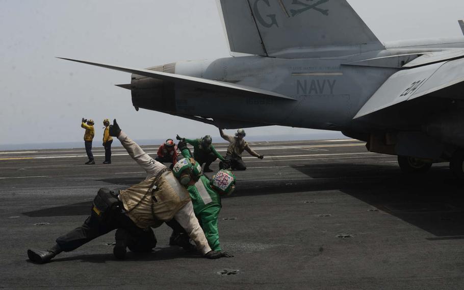 Deck crewmembers signal as an F/A-18 prepares to launch from the USS Harry S. Truman on Friday, June 3, 2016, in the Mediterranean Sea. The airstrikes, against the Islamic State group in Syria and Iraq, were the first by a carrier in the Mediterranean since 2003. 
