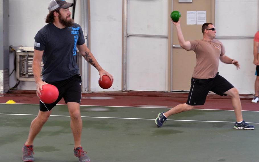Sean Walker, left, and Navy Petty Officer 1st Class William Lathan play dodge ball on an indoor tennis court at the U.S. Embassy during Kabul Fitness Festival, May 28, 2016.