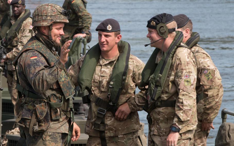 British and German troops take a break after quickly assembling a bridge across the 1,100-foot-wide Vistula River on Wednesday, June 8, 2016. The assembly was one component of the larger Anakonda exercise taking place across Poland.