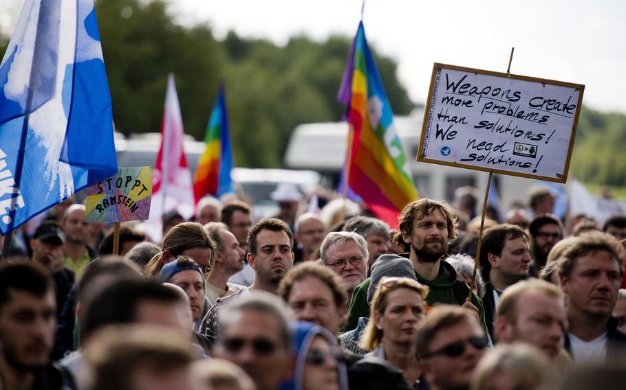 Protesters listen to a speaker during a demonstration outside Ramstein Air Base, Germany, Sept. 26, 2015. Several hundred people gathered to protest military activities at the base. Thousands of peace activists from across Germany and abroad are expected to demonstrate again outside Ramstein Saturday against the base's alleged role in U.S. drone operations.