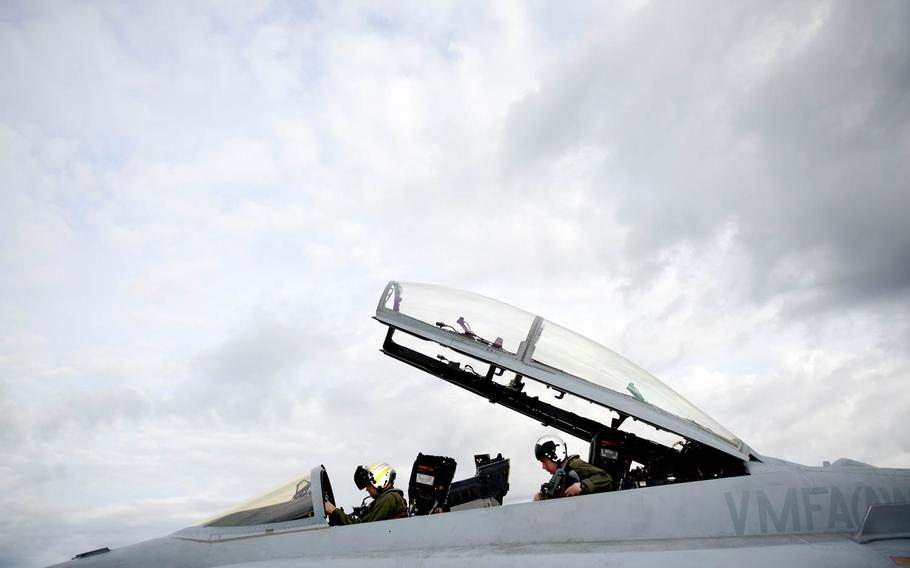 Marine Corps F-18 Hornet pilots assigned to Fixed Marine All-Weather Fighter Attack Squadron 242 at Marine Corps Air Station Iwakuni, Japan, secure themselves inside the cockpit, Tuesday, June 7, 2016, during Red Flag-Alaska drills at Eielson Air Force Base, Alaska.