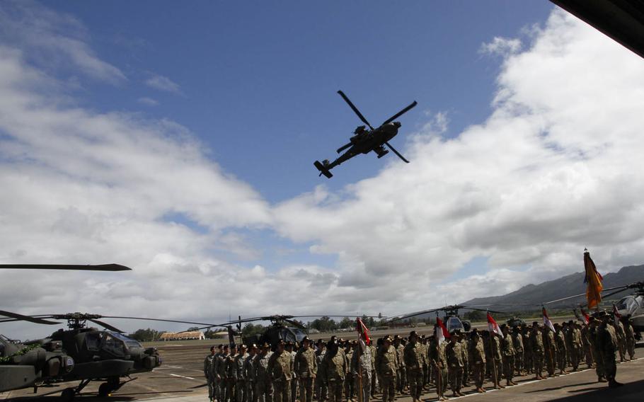 An Apache performs a flyover during a ceremony marking the arrival and readiness of 24 of the attack helicopters at Wheeler Army Airfield, Hawaii, Thursday, June 9, 2016.
