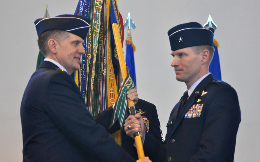 Lt. Gen. Timothy R. Ray offers the symbol of leadership for the 31st Fighter wing to Brig. Gen. Lance K. Landrum during a change of command ceremony Friday, June 10, 2016, at Aviano Air Base, Italy.