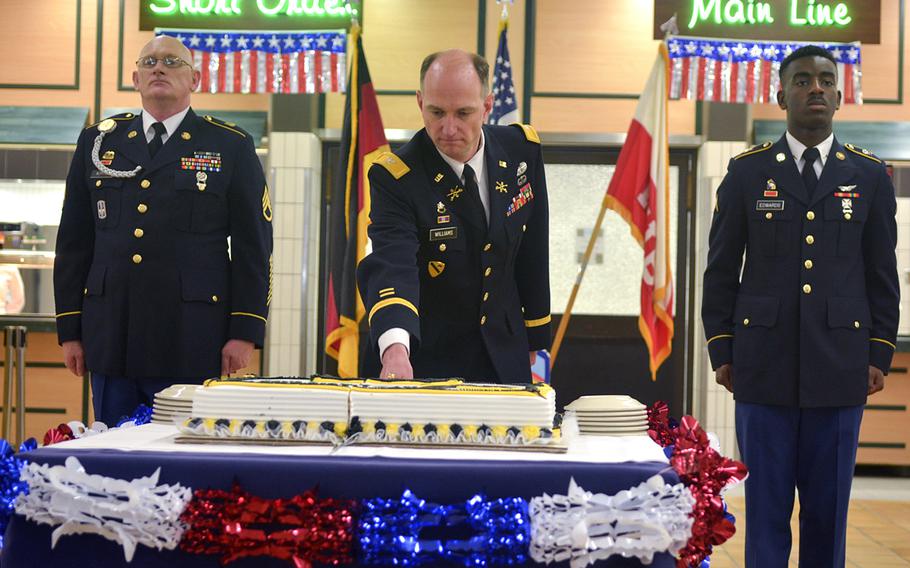 Col. Bill Williams, deputy chief of staff of U.S. Army Europe, cuts a cake during a ceremony at Clay Kaserne in Wiesbaden, Germany, June 14, 2016. Williams is flanked by Staff Sgt. Leonard Romine, left, and Pvt. Donte Edwards, who at 49 and 18, respectively, are the oldest and youngest soldiers in Wiesbaden.