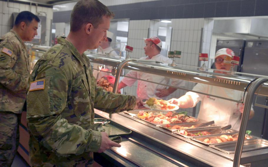A U.S. Army Europe soldier receives his plate from a Strong Europe dining facility contractor at Clay Kaserne in Wiesbaden, Germany, June 14, 2016. USAREUR marked the 241st anniversary of the creation of the U.S. Army with a ceremony and special meal service.