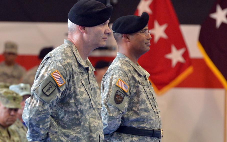 The incoming commander of Regional Health Command Europe, Col. Dennis LeMaster, left, and outgoing commander Brig. Gen. Norvell Coots listen to Lt. Gen. Nadja West, the Army surgeon general, at the unit's change of command ceremony in Sembach, Germany, Friday, June 24, 2016.