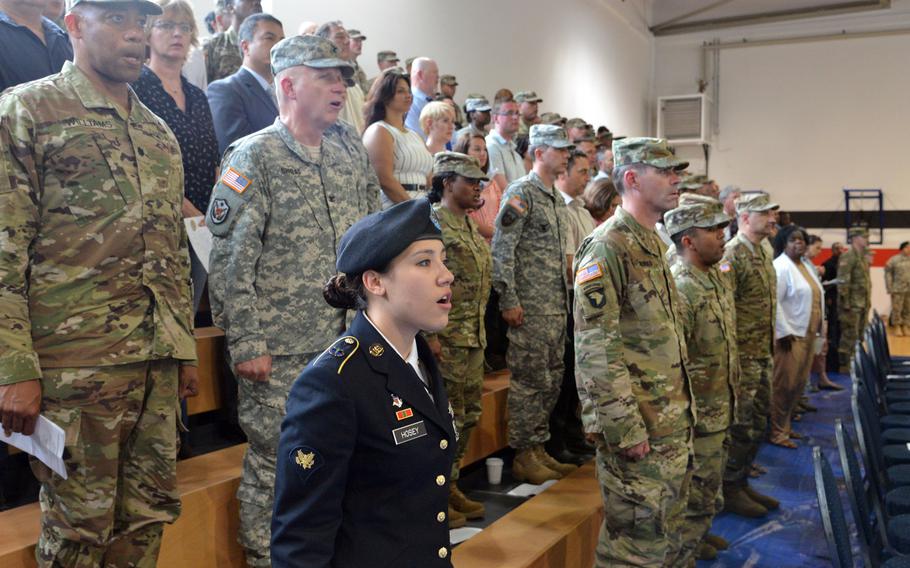 Spc. Alyssa Hosey of the Hohenfels health clinic, foreground, and other soldiers sing the Army Song at the conclusion of the Regional Health Command Europe's change of command ceremony in Sembach, Germany, Friday, June 24, 2016. Col. Dennis LeMaster took command from Brig. Gen. Norvell Coots at the ceremony.