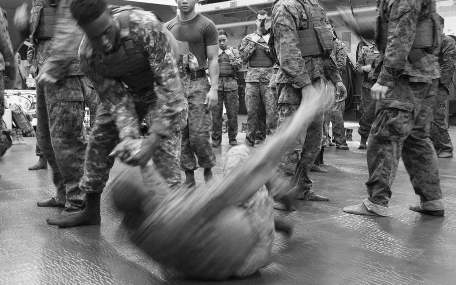 Seaman Enos Chapman executes a wrist-lock takedown of his opponent during Marine Corps Martial Arts Program training onboard the amphibious assault ship USS Boxer June 17, 2016.