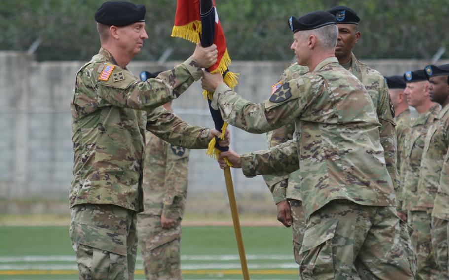 Maj. Gen. Theodore "Ted" Martin, 2nd Infantry Division commander, receives the brigade colors from outgoing 2nd Sustainment Brigade commander Col. Timothy White, left, at the brigade's change-of-command ceremony at Camp Carroll, South Korea, Wednesday July 20, 2016. Incoming brigade commander Col. Kenneth Williams watches at right.