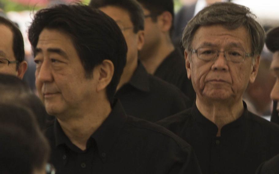 Okinawa Gov. Takeshi Onaga, right, walks with Japanese Prime Minister Shinzo Abe during a memorial service last year honoring the fallen men and women of the Battle of Okinawa at Okinawa Peace Memorial Park. Okinawan courts ruled against anti-base governor Friday, Sept 16, 2016, saying his failure to retract the revocation of a landfill permit central to Marine Corps Air Station Futenma's relocation is illegal.