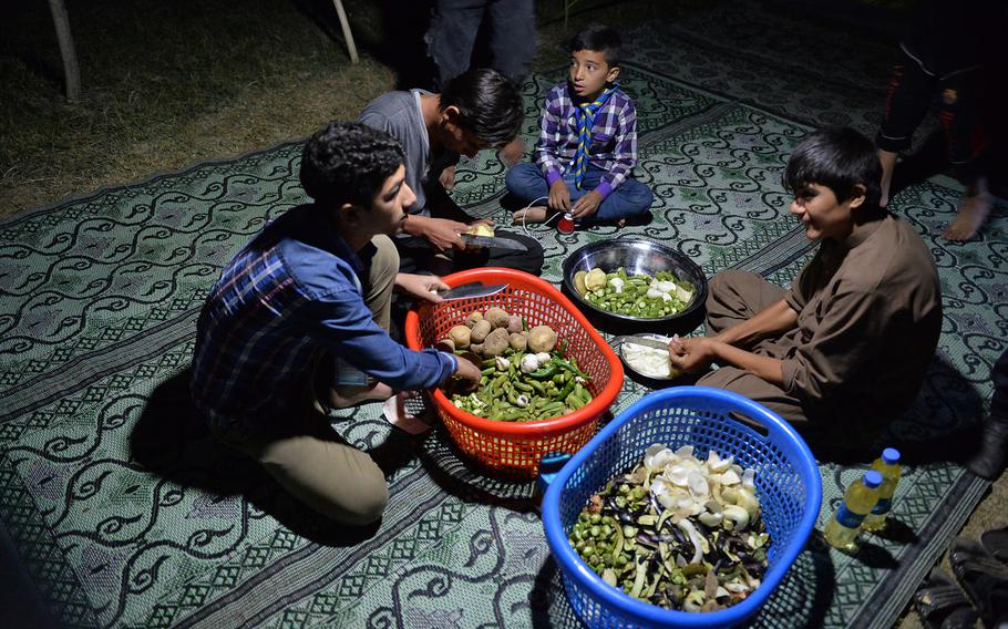 Boy scouts slice okra and peel potatoes and onions on Sept. 8, 2016, part of camp duties during a three-day campout in Kabul. The event was a rare opportunity for the children to escape the violence that is a part of daily life in Afghanistan.