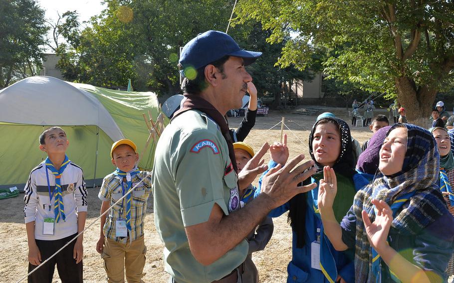 Parsa's Mohsin Arif, a scout trainer and scoutmaster, speaks to Afghan girl scouts begging for a turn to climb a 30-foot rope net climbing wall at a camporee event on Sept. 8, 2016.