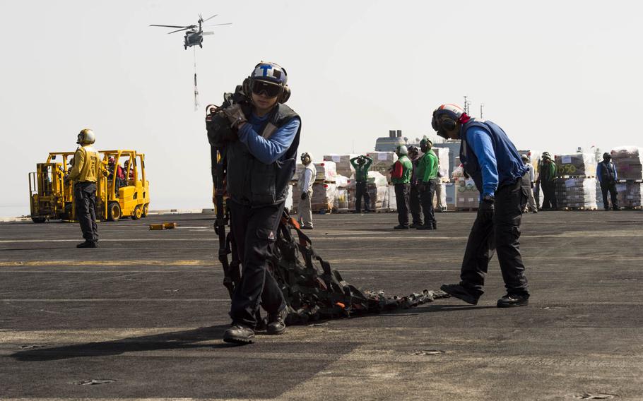Seaman Skyler Vanoosten, whose rate was Aviation Boatswain's Mate Handling, aboard the aircraft carrier USS Harry S. Truman, carries a net that was used to hold and transport a crate during a replenishment at sea across the flight deck on April 26, 2016.  The Navy has changed the enlisted rating system and no longer has rating titles, instead addressing personnel by their rank.  The Navy also no longer distinguishes between airman, fireman, and seaman.