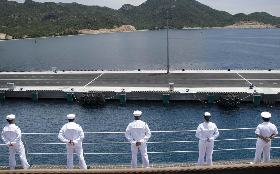 Sailors aboard the submarine tender USS Frank Cable man the starboard-side rails while pulling into Cam Ranh Bay, Vietnam, Oct. 2, 2016. The submarine tender and destroyer USS John S. McCain this week became the first commissioned Navy ships since the Vietnam War to moor at the strategically important South China Sea port.