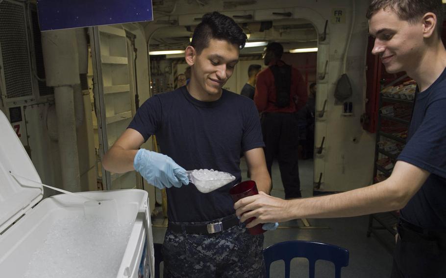 Seaman Jesus Diaz, left, mans the ice station in the USS Dwight D. Eisenhower's forward mess decks, handing out ice to sailors, on Aug. 24, 2016.  During the summer months, Ike sailors had to combat temperatures well above 100 degrees while deployed in the 5th Fleet area of operations.  Personnel used the acronym H.E.A.T., which stands for hydrate, eliminate, acclimate and treat, to mitigate the risk of heat injury.