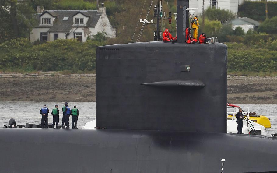 Crewmembers aboard the submarine USS Tennessee prepare for arrival at Faslane naval base, Scotland, Friday, Oct. 7, 2016.