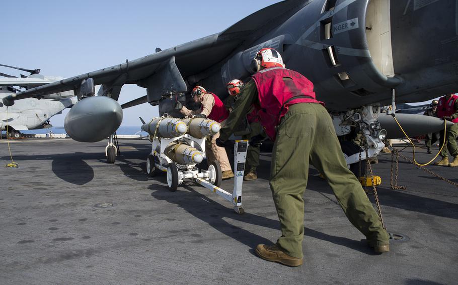 U.S. Marines attach a GBU-54 laser joint direct attack munition bomb to an AV-8B Harrier from the 22nd Marine Expeditionary Unit aboard the amphibious assault ship USS Wasp on Oct. 2, 2016. 