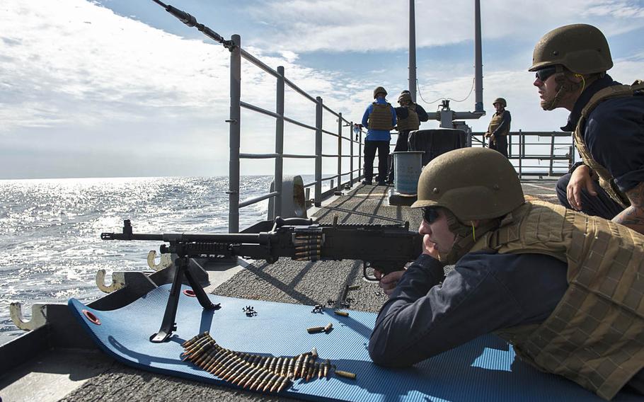 Petty Officer 3rd Class William Sweeney fires a machine gun during a weapons exercise aboard the guided-missile cruiser USS Chancellorsville in waters surrounding the Korean peninsula, Tuesday, Oct. 11, 2016.