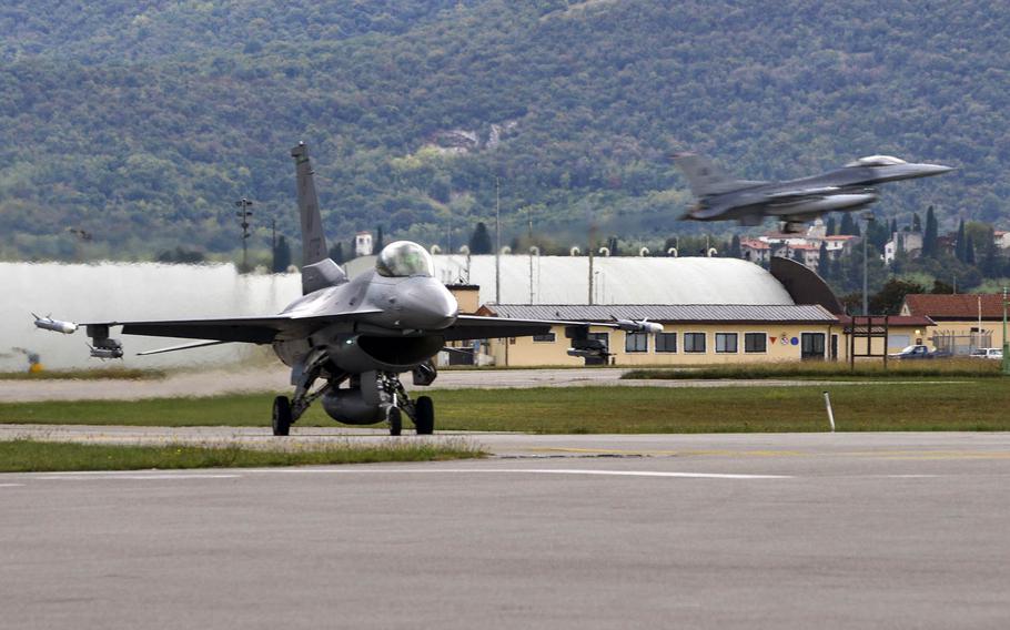 A 555th Fighter Squadron F-16 Fighting Falcon taxis across the runway while a 510th Fighter Squadron F-16 lands at Aviano Air Base, Italy on Oct. 5, 2016. U.S. Air Force F-16s from Aviano have deployed to Djibouti to protect American interests in South Sudan.