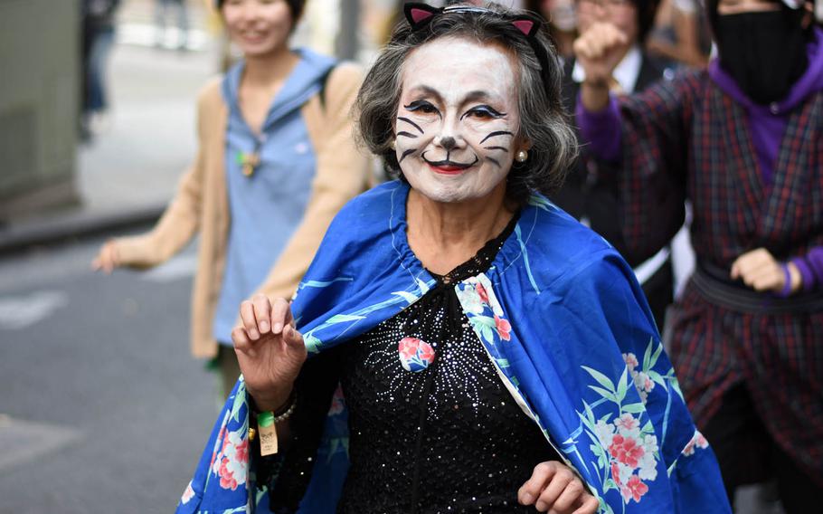 A woman marches in the Bakeneko festival parade, Sunday, Oct. 16, 2016, in Tokyo. The annual Halloween-like festival, whose name roughly translates to "ghost cat with supernatural powers," includes a long and lively parade of costumed revelers, live music and street dancing.
